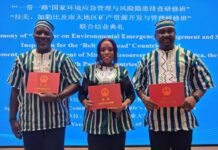 ICPNC Team Completes Environmental Response and Peace Seminar in China Three certificate recipients pose on a stage, each holding a red certificate, wearing matching striped outfits, in front of a blue ceremony backdrop that includes multilingual text.