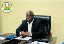 Transport Minister Urges SLCAA, Aviation Operators to Intensify Preparations for 2027 ICAO Safety Audit Bald man in a dark suit sits at an office desk with papers and a phone; Ministry of Transport and Aviation logo in the top-left.