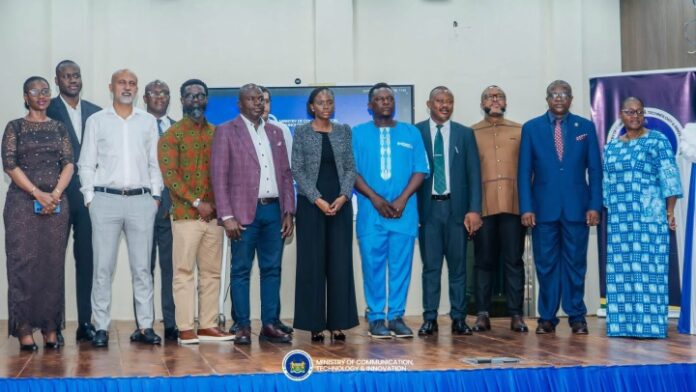 Diverse group of 12 professionals standing on a stage for a formal group photo at a Ministry of Communications, Technology & Innovation event.