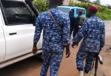 OSD Officer Killed in Madonkeh; Two Soldiers & Over 20 Others Arrested Group of soldiers in blue camouflage uniforms walking along a dusty road beside a white vehicle; one man wears a red beret and carries a rifle nearby.