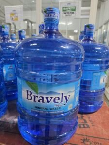 | The Calabash Newspaper Large blue Bravely mineral water jug on a store shelf, with other bottles in the background.