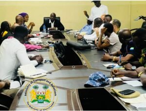 Group of officials around a conference table in a meeting, with the Sierra Leone Ministry of Transport and Aviation seal in the foreground.
