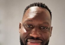 QNET Announces New Global and African Leadership to Drive Next Phase of Growth in Africa and beyond Professional headshot of a smiling man in a navy suit, white shirt, and blue patterned tie against a neutral background.