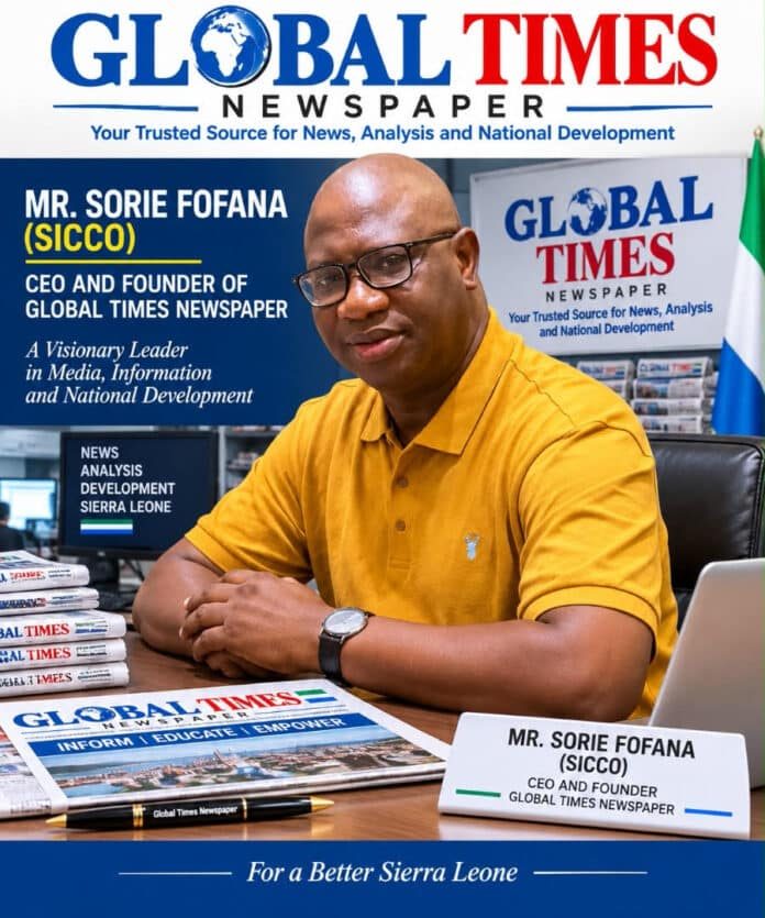 Portrait of Mr. Sorie Fofana, CEO and founder of Global Times Newspaper, seated at a desk with Global Times branding in the background.
