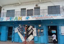 Peak Electrical in the Spotlight Over Alleged Sale of Suspected Fake RR Cables Exterior of PEAK Electricals & Electronics storefront with blue doors open and outdoor lighting fixtures displayed on a rack in front of the shop.