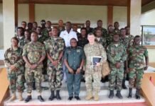 RSLAF, Michigan National Guard Strengthen AFL Military Justice System Group photo of soldiers and officers in camouflage uniforms standing on the steps of a building in formation.