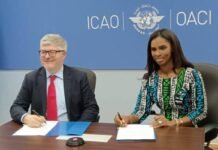 ICAO Trains Sierra Leone Civil Aviation Officials on Insider Risk Mitigation Two officials sign documents at a table during a formal signing, with an ICAO/OACI backdrop.