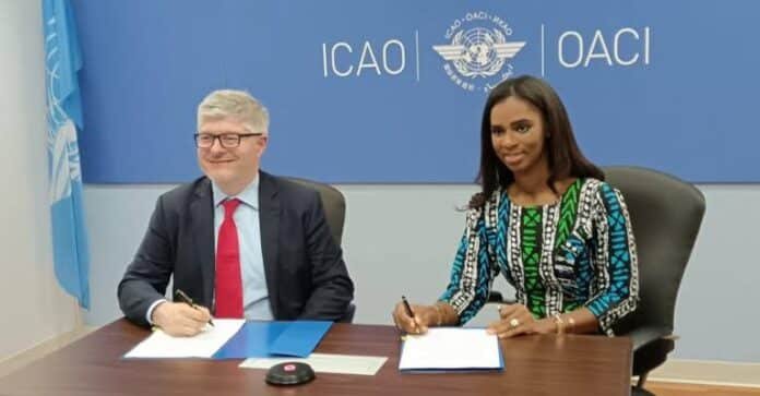 Two officials sign documents at a table during a formal signing, with an ICAO/OACI backdrop.