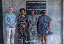 MoCTI, UN Strengthen Cooperation on Data Governance and Digital Infrastructure Four people stand in front of a dark stone plaque commemorating the commissioning of the National Communications Authority headquarters.