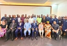 Health Ministry Enrolls 60 Biomedical Engineers to Strengthen Medical Equipment Safety Group of about 30 professionals posing for a group photo in a conference room; front row seated in suits and dresses, back row standing in smart casual attire.