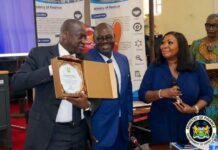 Finance Minister, World Bank Vice-President Reaffirm Stronger Partnership Three professionals at a government awards event; man on the left presents an award in a wooden box to a smiling colleague, while a woman speaks into a microphone in the foreground.