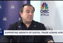 Africell Secures $99.6 Million US Financing to Advance Telecom Technology in Africa Man in a dark blazer speaks during a CNBC Africa interview about supporting growth of digital trade in Africa.