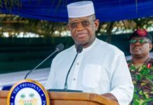 President Bio Seeks Supreme Court Opinion Ahead of October 7 Constitutional Amendment Hearing President delivering a speech at a podium, wearing a white traditional outfit and cap, with a 'The President' seal on the lectern and a uniformed officer in the background.
