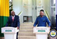 Sierra Leone, Guinea Seal Six-Point Deal to Strengthen Border Security, Trade and Protection of Nationals Two officials stand at separate podiums during a Guinea–Sierra Leone work visit, in front of a government building with welcome banners.