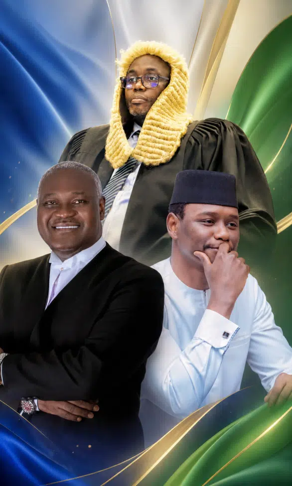 Three men posing for a portrait: a judge in ceremonial gown and fur wig stands behind two formally dressed men in suits.