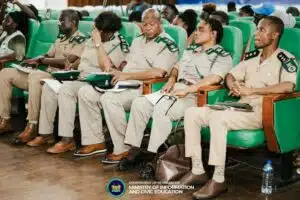 Uniformed officials seated in a row of green chairs at a government briefing; Ministry of Information and Civic Education logo visible.