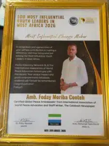 Framed award certificate titled '100 Most Influential Youth Leaders in West Africa 2026' with a photo of a man in a white striped shirt; date August 29, 2026, signatures present in bottom area.
