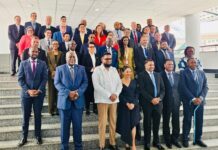 At 3rd Global RSOO/RAIO Forum in Guyana… SLCAA DG Advocates Stronger Regional Coopération to Advance Aviation Safety Diverse group of professionals in business attire posing for a group photo on a wide stairway in a modern building.