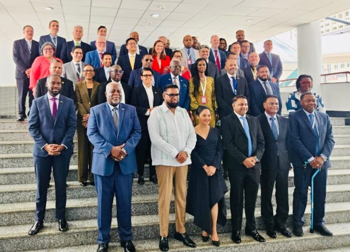 Diverse group of professionals in business attire posing for a group photo on a wide stairway in a modern building.