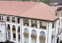 58-Year-Old Chef Remanded Over Alleged Murder of Woman in Tombo Aerial view of a large white colonial-style building with a red tile roof, arched windows and balconies, surrounded by trees and a parking area.