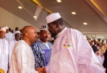 Vice President Joins President Doumbouya as Guinea Marks 68th Independence Anniversary Two men in white traditional attire shake hands at a formal event, with onlookers and a government seal visible in the foreground.