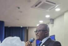 Chief Justice Calls for Human-Centred AI Adoption in Sierra Leone’s Judiciary Hon. Chief Justice Kamanda delivering a speech at a podium in a suit, microphone in hand.