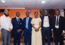 During Customer Service Week 2026… Orange Sierra Leone Champions Culture of Going the Extra Mile for Customers Six professionals in formal attire posing for a group photo at a corporate event, with an orange branded backdrop behind them.