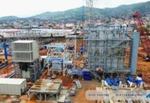 $418 Million Nant Power Project Reaches 68% Completion, Targets March 2027 Electricity Supply Construction site with tall steel scaffolding, machinery, and a red crane, set against a rural hillside backdrop.