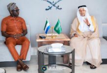 Information Minister, Saudi Ambassador Discuss Stronger Cooperation in Technology, Culture & Investment Two men sit on opposite couches in a formal meeting, with Sierra Leone and Saudi flags on a table between them.