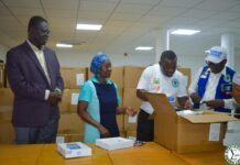Ahead of December Enumeration, Stats SL Receives 25,000 Digital Census Tablets Four volunteers pack supplies at a table with large cardboard boxes in a storage room.