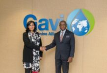 Gavi Commits US$60.9 Million to Sierra Leone as President Bio Pushes for Stronger Immunization Support Two formally dressed individuals shake hands in front of the Gavi Vaccine Alliance logo backdrop.