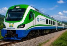SLRDRA Presents First-Year Achievements to President Bio, Outlines Plans to Revive Sierra Leone’s Railway Network Modern green, white, and blue Sierra Leone Railways passenger train on a single-track line under a blue sky.