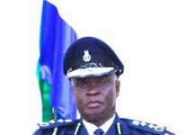 US State Department Retains Sierra Leone on Tier 2 Despite Progress in Fighting Human Trafficking High-ranking officer in a blue ceremonial uniform with medals and aiguillette, seated with hands clasped; flag in the background.