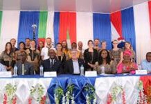 Peace Corps Celebrates 64 Years of Supporting Sierra Leone’s Education Sector Group photo of officials and delegates at a formal ceremony, seated at a decorated table with a red, white, and blue backdrop behind them.