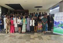 Trade Ministry Launches AfCFTA Trade Guide to Help Businesses Access African Markets Group portrait of diverse attendees in bright clothing posing on steps at a formal event, with a banner about Sierra Leone trade information.