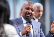Vice President Highlights “Politics of Painful Choices” Amid Rising Debt and Global Economic Shocks Speaker in a blue suit speaks into a handheld microphone at the Hamburg Sustainability Conference, gesturing with his right hand.