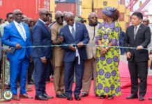 President Bio Commissions SLOSCO’s 50-Vessel Shipping Initiative to Transform Sierra Leone’s Maritime Industry Dignitaries in suits at a ribbon-cutting ceremony on a red carpet, with shipping containers in the background.