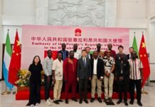 Chinese Embassy Engages Journalists on Xi Jinping’s Development Initiatives and Mining Cooperation Group of people posing for a photo in front of the Chinese Embassy banner, flanked by flags, on a red carpet.