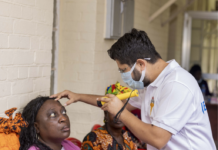 Choithram and Noor Dubai Foundation Restore Sight to Over 1,500 Patients in Second Phase of Cataract Outreach Clinician in a white polo and mask uses a handheld diagnostic device on a woman's forehead during a health screening.
