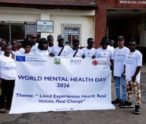 Group of people holding a banner for World Mental Health Day 2026, with theme 'Lived Experiences Heard: Real Voices, Real Change'.
