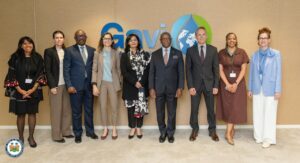 | The Calabash Newspaper Group of diverse professionals posing for a photo in front of a Gavi logo backdrop at a formal event.