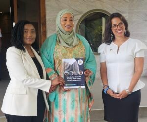 | The Calabash Newspaper Three women pose together; the center woman in a green hijab holds a brochure about trading goods under the ACFTA agreement while two others smile beside her.
