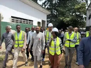 Group of people in high-visibility vests and hard hats walking together at a construction site.