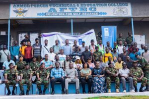 | The Calabash Newspaper Group photo of students and soldiers on stairs in front of an AFTEC building with a banner and crest visible